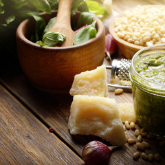 Pesto sauce ingredients and utensils on wood table