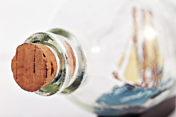 Closeup image of a ship in a bottle, shallow focus on cork