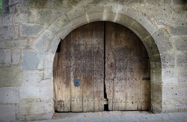 The old wooden doors in an Ancient city wall. Vintage style picture.
