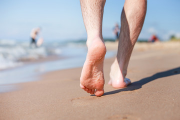 Closeup of a persons feet walking on the beach