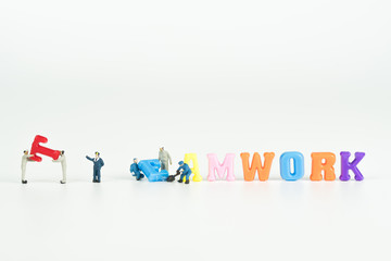 text TEAMWORK colorful word with miniature people on white background