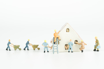 Group of engineer workers are repairing house on white background.
