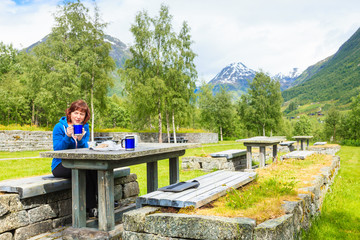 Fototapeta na wymiar Traveler woman have lunch on nature in norwegian mountains