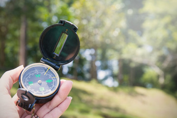 Hand holding compass at forest © paulaphoto