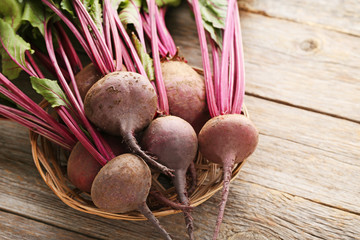 Fresh and ripe beets in basket on wooden table