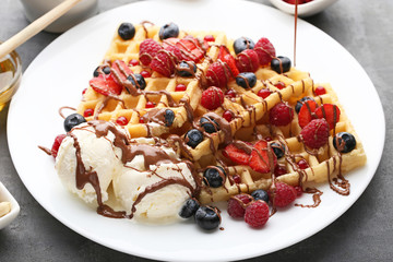 Sweet waffle with berries and ice cream on grey wooden table