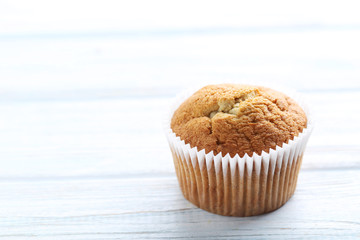 Tasty muffin on a white wooden table