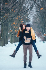 Fototapeta na wymiar Smiling couple walking in snowy woods together