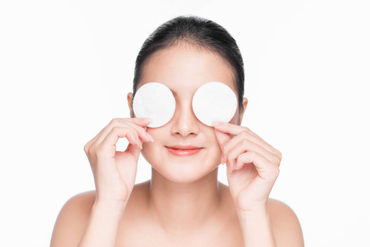 Young asian girl cares for face skin relaxation using cotton pad.