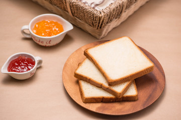 Fototapeta na wymiar Toast with strawberry and orange jam on a plate on table.