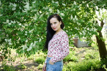 charming brunette girl in the garden near the flowering tree