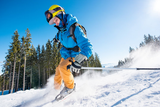 Male skier skiing on fresh snow in the mountains on a sunny beautiful day extreme fun happiness activity lifestyle concept