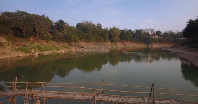 Aerial Pullback Reveal Of Bamboo Bridge Over Nam Khan River, Luang Prabang, Laos
