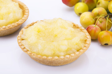 Still life. Two cakes with apple jam, bunches of small apples on a white background