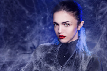 Fantasy Halloween Vampire woman portrait. Beauty Sexy Vampire in a cemetery, at night wearing...