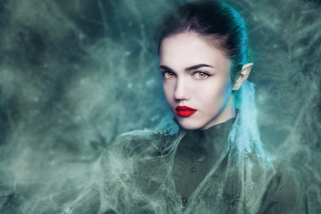 Fantasy Halloween Vampire woman portrait. Beauty Sexy Vampire in a cemetery, at night wearing...