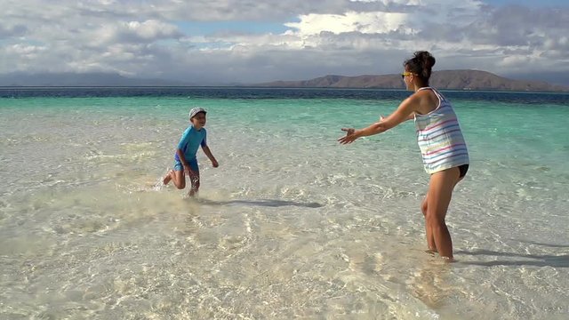 Boy run to his mother on idyllic beach, slomotion at 240fps
