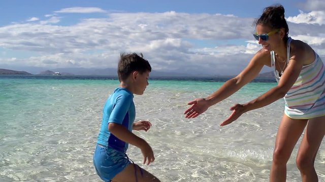 Boy run to his mother on idyllic beach, slomotion
