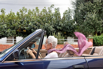 old woman driving a convertible car