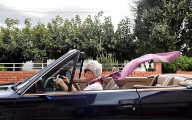 old woman driving a convertible car