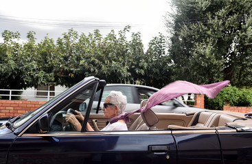 old woman driving a convertible car