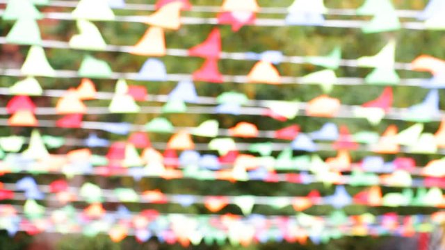 Multicolored festive small flags of a triangular shape swaying in the wind