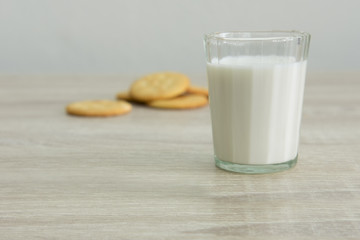 MILK GLASS AND CRACKERS
A glass of milk with pile of crackers on the wood top table. 