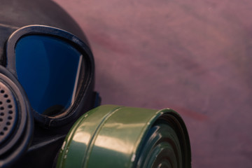 Black gas mask with blue reflection in the glass on a beautiful background.