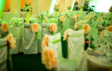 Green chairs in the restaurant decorated with orange flowers