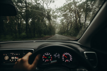 Inside view of car steering wheel while driving across Australian road.