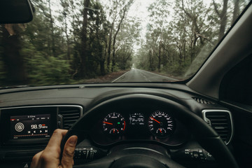 Inside view of car steering wheel while driving across Australian road. - 171729388