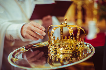 Golden crown lies on a silver tray