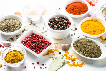 Various spices in a bowls on white table.