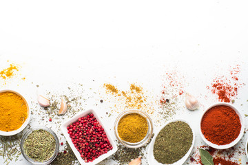 Various spices in a bowls on white background. Top view copy space.