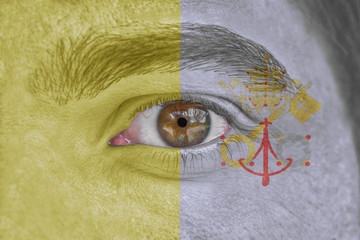 Human face and eye painted with flag of Vatican City
