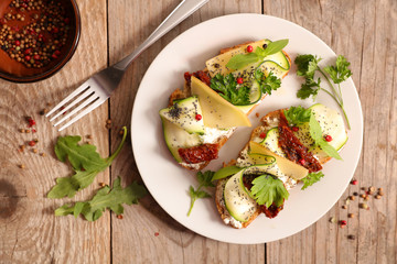 bread toast with cheese, cucumber and dried tomato