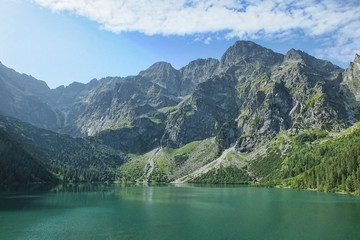 A lovely summer morning in Tatra National park near Morskie Oko - one of the most popular tourist destinations. Crystal clear mountain water reflects the highest peaks of Tatras on the lake.