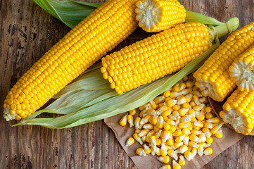 Close-up of corn grains with tasty, ripe ears of corn, isolated on vintage wooden table. Top view