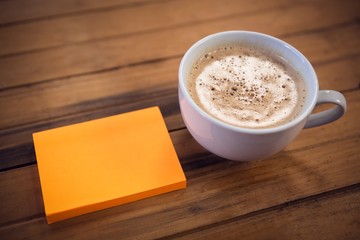 High angle view of adhesive notes by coffee cup
