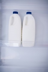 Close up white milk bottles in refrigerator