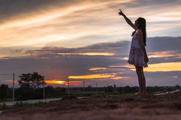 Beautiful asian woman standing on the .mound with sunset