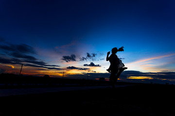 Fototapeta na wymiar Silhouette of woman posing at sunset or sunrise