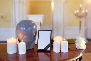 photo frame, cremation urn and candles in church - obrazy, fototapety, plakaty