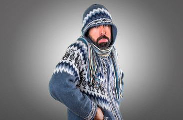 Fototapeta na wymiar Sad man with winter clothes on grey background