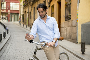 young happy man smiling using mobile phone on vintage cool retro bike