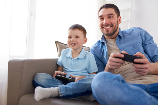 father and son playing video game at home