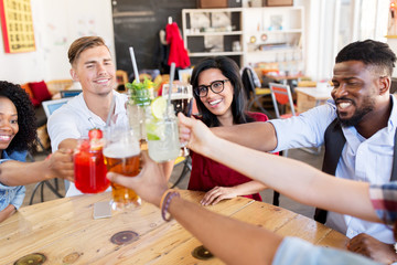 friends clinking glasses with drinks at restaurant
