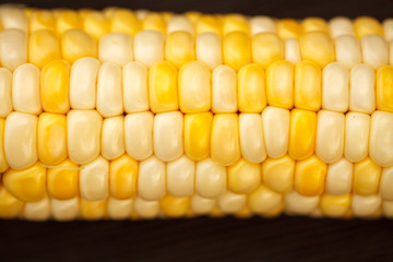 Corns of fresh corn on a wooden texture. View from above. Close-up.