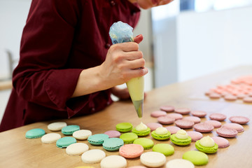 chef with injector squeezing filling to macarons