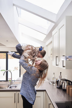 Mother and little daughter having fun together in the kitchen